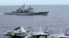 FILE - U.S fighter jets on standby at the upper deck of a USS George Washington aircraft carrier while the USS Cowpens passes by, in the South China Sea, 170 nautical miles from Manila, September 2010.