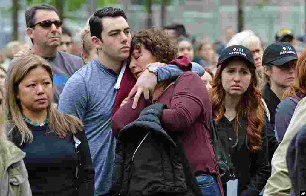 Dua warga AS saling berpelukan saat menyaksikan acara pembukaan Museum Serangan September 11 di New York.
