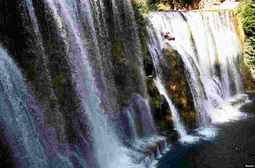 一名选手参加在波斯尼亚和黑塞哥维那老城 Jajce 举行的年度国际瀑布跳水比赛。（2017年8月5日）