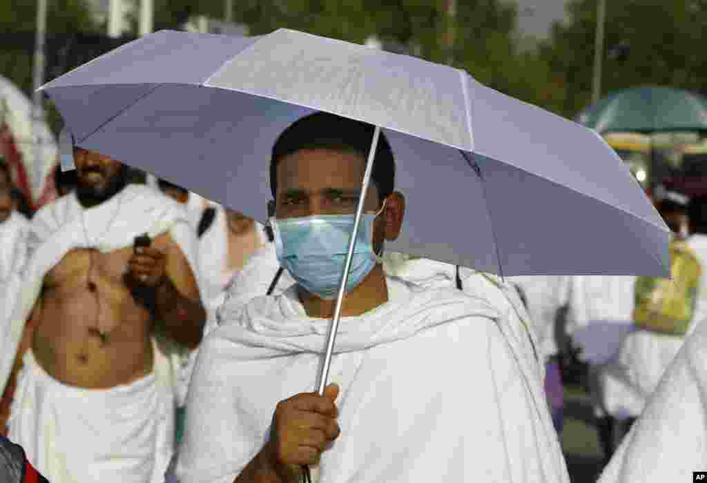 A Muslim pilgrim wears medical mask as he walks in Arafat near the holy city of Mecca, Saudi Arabia, Oct. 14, 2013.