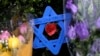 FILE - A Star of David fashioned from ice pop sticks hangs from bushes outside the Tree of Life Synagogue in Pittsburgh, Nov. 20, 2018. 
