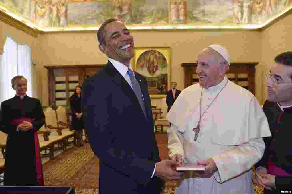 Pope Francis exchanges gifts with U.S. President Barack Obama during a private audience at Vatican City, March 27, 2014. 