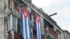 Un hombre cuelga una bandera cubana para tapar las ventanas de la casa de Yunior García, actor, dramaturgo y líder del grupo Archipiélago, en La Habana, el 14 de noviembre de 2021.