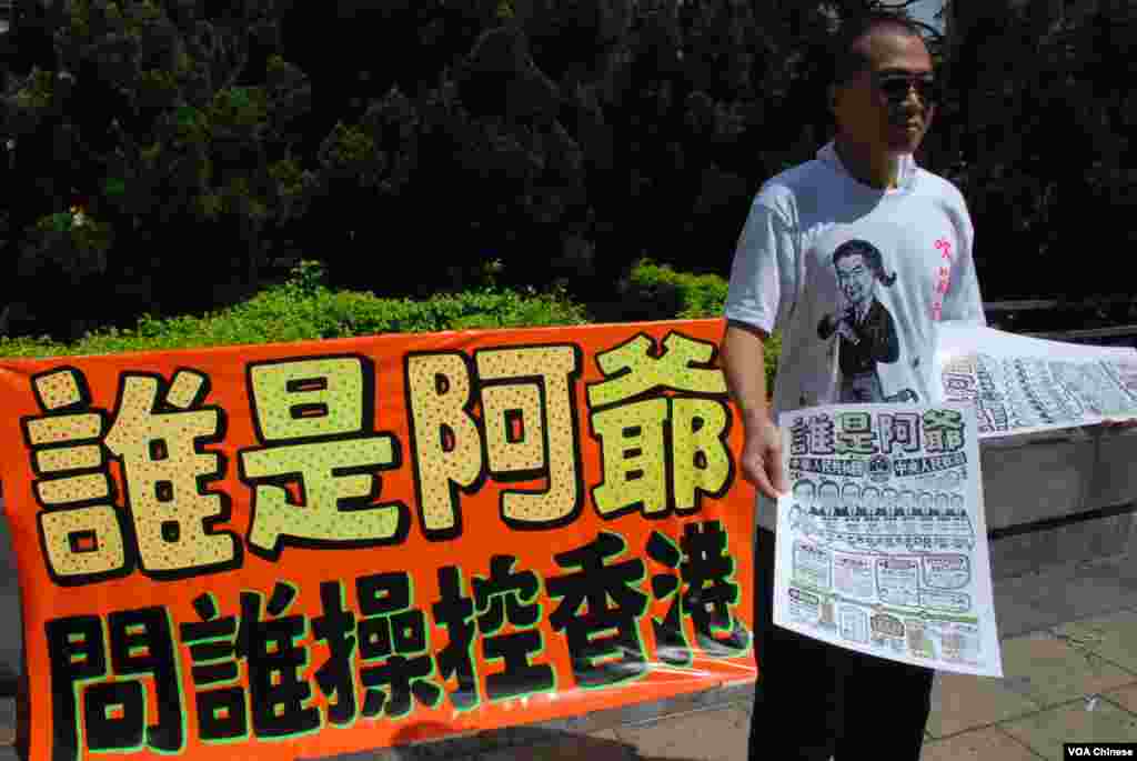 獨立藝術家石家豪向遊行人士派發他繪製的漫畫,介紹北京領導人的架構