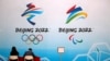 工作人员坐在北京2022年冬奥会标志旁