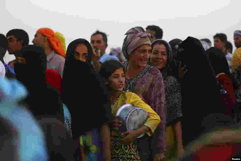 Para pengungsi Irak yang mengungsi dari kekerasan yang terjadi di kota Mosul, mengantre makanan gratis untuk buka puasa di kamp pengungsi Khazer di Irbil, Kurdistan (29/6).