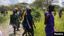 South Sudanese women walk to the site of a U.N. World Food Program (WFP) food aid air drop near the town of Katdalok, in Jonglei State of South Sudan, July 30, 2018.