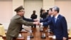 韩国总统的国家安全顾问金宽镇(右)与朝鲜军队的最高政治官（左）握手。