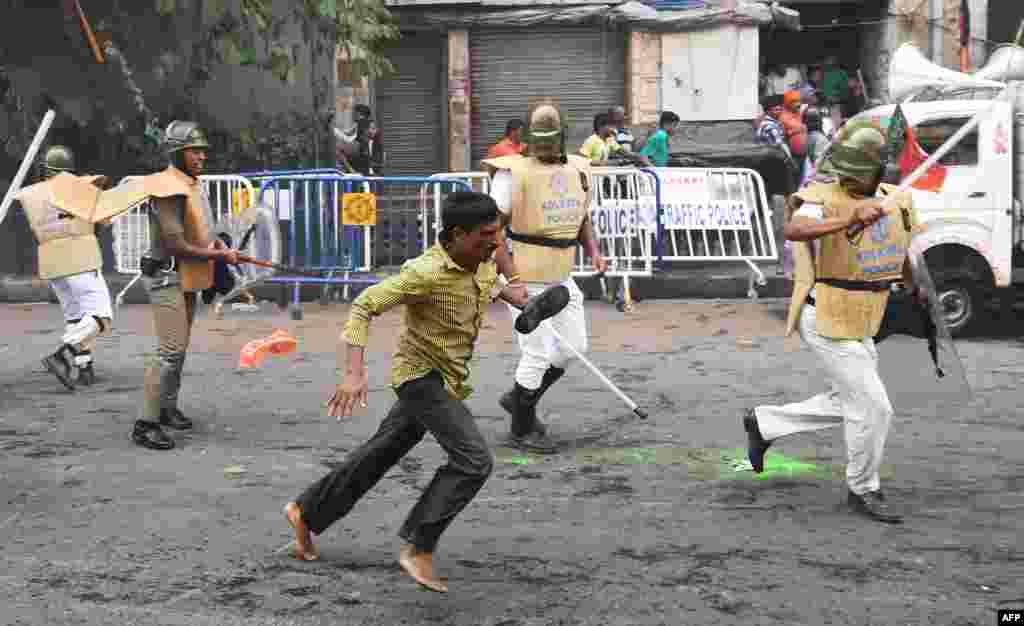Para pendukung partai Bhartiya Janata Party (BJP) lari melewati polisi di Kolkata,India, dalam aksi protes menentang kekerasan oleh polisi terhadap rekan partai mereka.