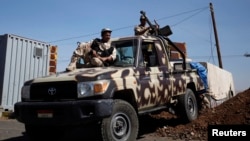 FILE - Army soldiers are seen at a checkpoint outside Amran city, the capital of Amran province, north of Sanaa, amid tension with militants of the Shi'ite Houthi group, Apr. 13, 2014. 