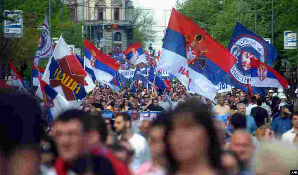 Para demonstran di Beograd melambaikan bendera dalam protes terhadap kesepakatan yang disponsori Uni Eropa untuk menormalkan hubungan antara Serbia dan Kosovo yang memisahkan diri dari Serbia.