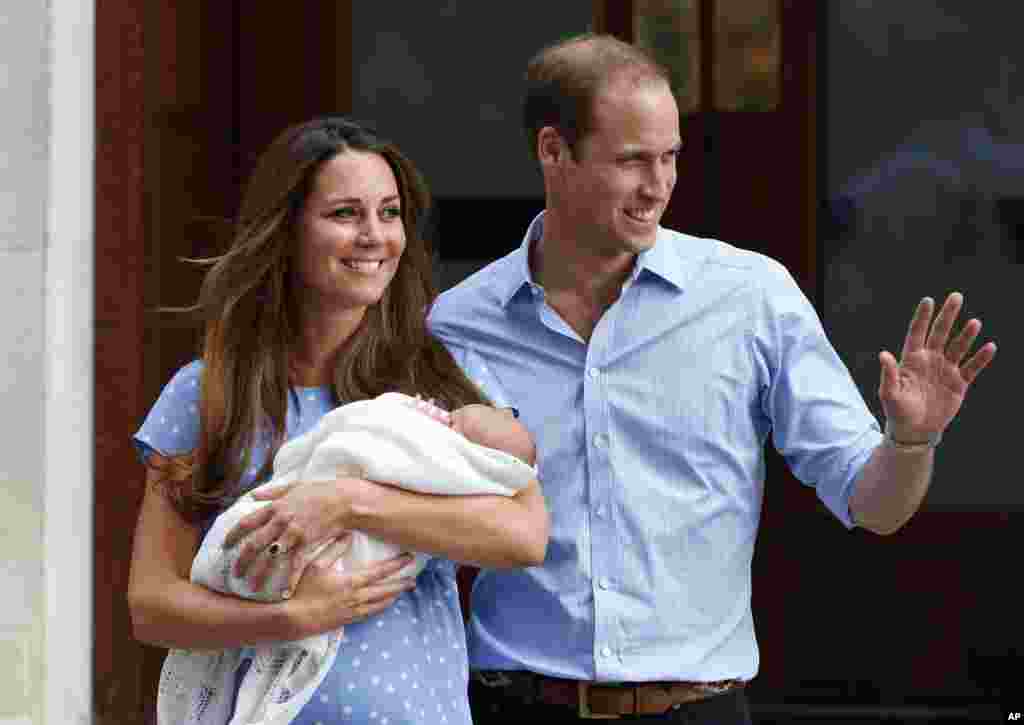 Pasangan Kerajaan Inggris, Pangeran William dan Kate, Duchess of Cambridge, berpose bersama bayi mereka yang baru lahir George di luar Rumah Sakit St. Mary's di London (23/7). (AP/Lefteris Pitarakis)