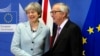 英国首相特蕾莎.梅（左）和欧洲委员会主席容克在布鲁塞尔谈判前握手