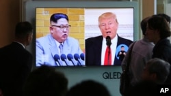 Stanovnici Seula gledaju TV prilog o američkom predsedniku Trampu i severnokorejskom lideru Kim Džong Unu. 