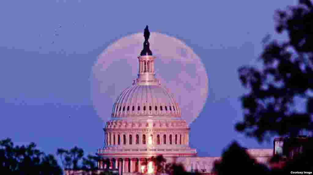 Supermoon terlihat di belakang gedung Kongres AS atau gedung 'Capitol' di Washington DC. (Foto courtesy: Bill Workinger/VOA).