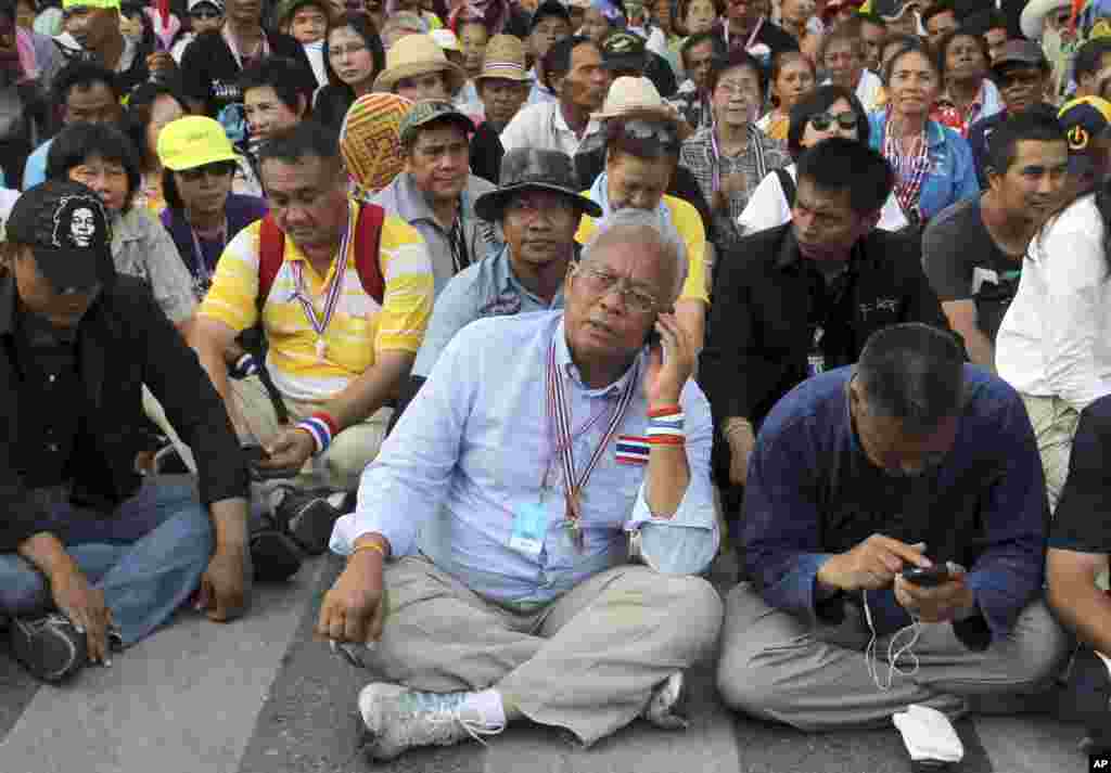 Pemimpin protes Suthep Thaugsuban (tengah) sedang menelepon dalam demonstrasi di luar gedung parlemen di Bangkok (12/5). (AP/Apichart Weerawong)