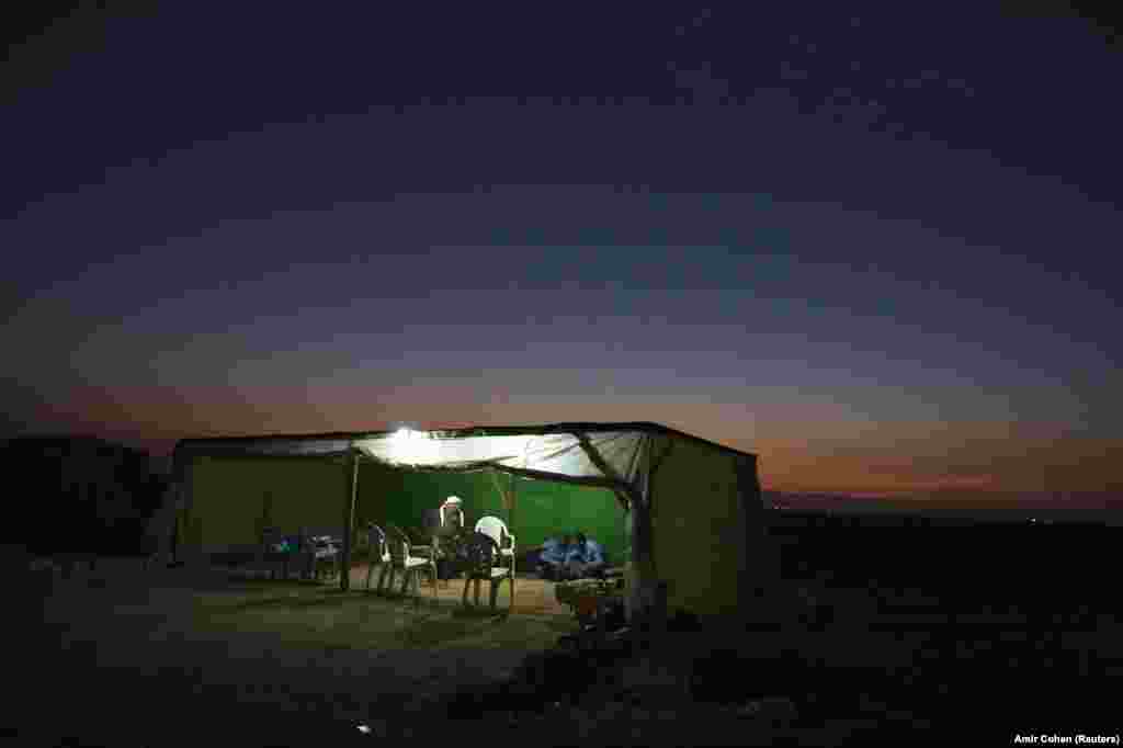 Bedouin men sit in a village known by Bedouin Arabs as al-Arakib, one of many ramshackle desert communities whose names have never appeared on any official map, November 2, 2011.