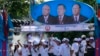 Supporters of Prime Minister Hun Sen's Cambodian People's Party dance under portraits of the party leaders, from left, Chea Sim, Hun Sen and Heng Samrin, during an election campaign in Phnom Penh, file photo. 