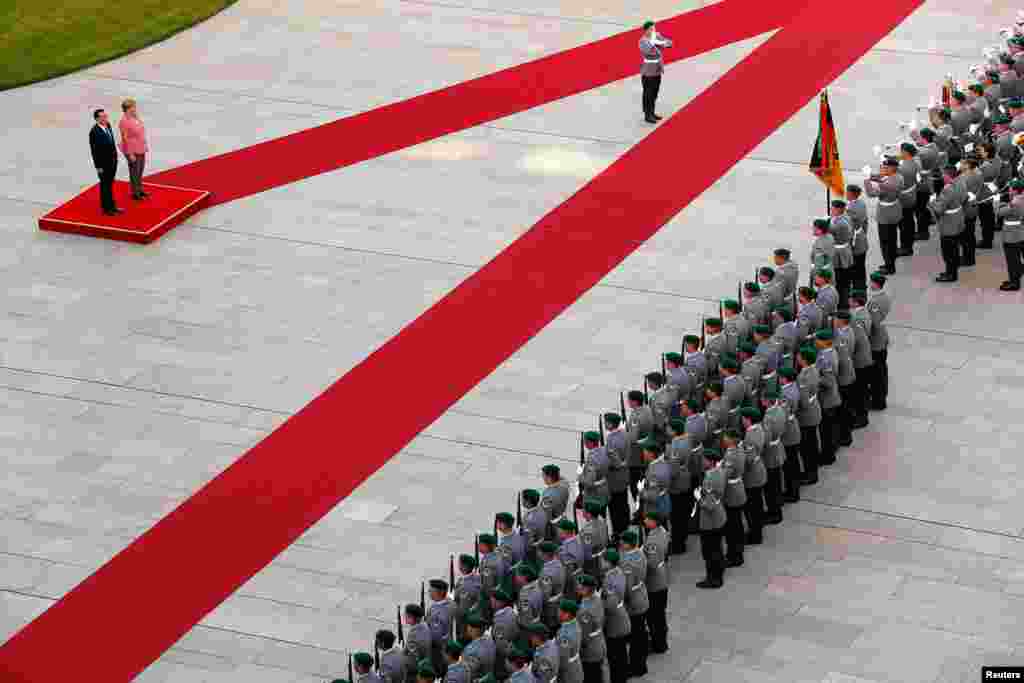 Kanselir Jerman Angela Merkel menyambut kunjungan PM China Li Keqiang di depan pasukan kehormatan Jerman pada upacara di Berlin.