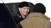 Army Pfc. Bradley Manning, center, steps out of a security vehicle as he is escorted into a courthouse in Fort Meade, Md., November 28, 2012.