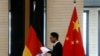 在北京举行中德经贸部长会议期间一名男子走过中国和德国国旗。（2016年11月1日）
