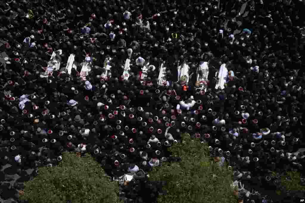 Mourners from the Druze minority surround the bodies of some of the 12 children and teens killed in a rocket strike at a soccer field, during their funeral, in the village of Majdal Shams, in the Israeli-annexed Golan Heights. It's the deadliest strike on an Israeli target along the country's northern border since the fighting between Israel and the Lebanese militant group Hezbollah began.