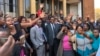 Friends and relatives of 27 people arrested during last week’s opposition protests celebrate outside the Harare Magistrates Court after their loved ones had been granted bail, in Harare, Zimbabwe, Aug. 7, 2018. (C. Mavhunga/VOA)