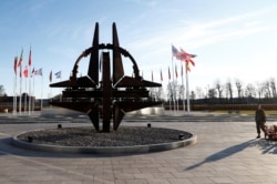 FILE - A man stands outside NATO headquarters in Brussels, Belgium, Jan. 6, 2020.