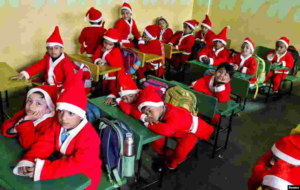 2017年12月20日，在印度昌迪加尔的一所学校，穿着圣诞老人服装的儿童坐在教室内，准备参加圣诞节庆祝活动。