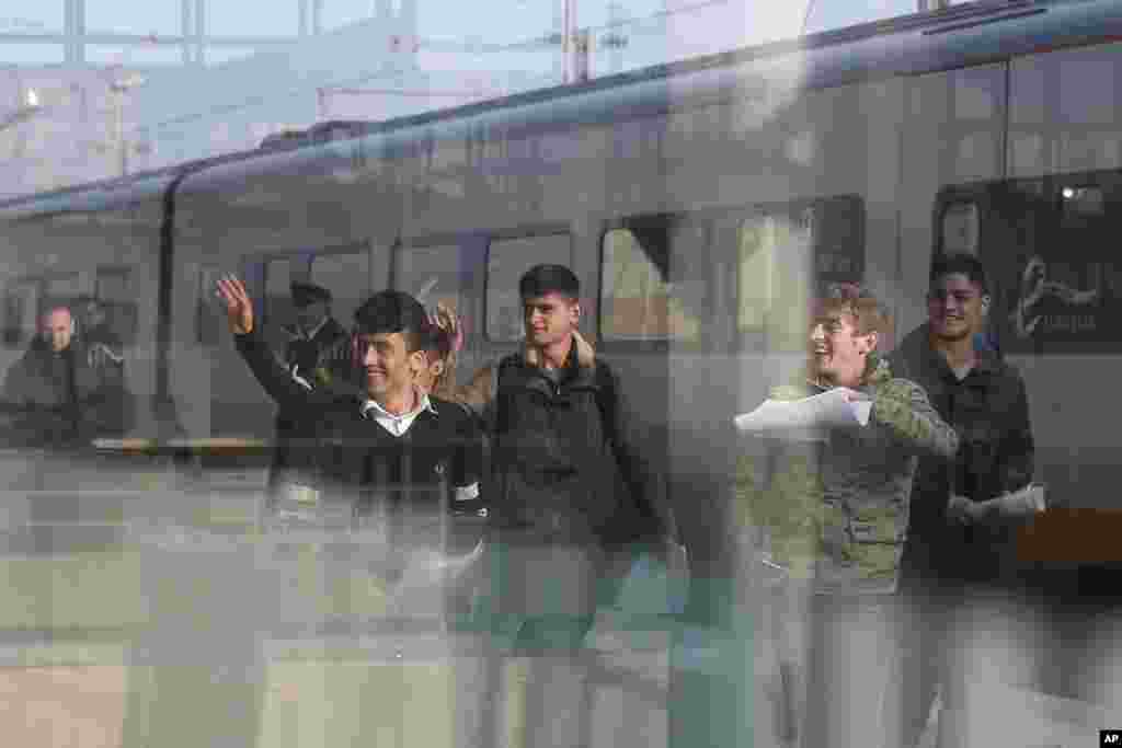 Anak-anak migran Afghanistan melambai di stasiun kereta Calais, Perancis utara, untuk menuju Inggris.