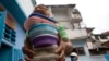 Un voluntario lleva recipientes con arroz, pollo y ensalada para los residentes del comedor de beneficencia San Antonio de Padua en el barrio Petare de Caracas, el 10 de junio de 2021.