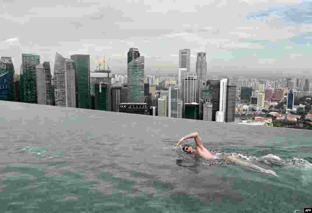 Juara dunia renang asal Australia, Christian Sprenger berenang di kolam renang yang terletak di atas atap hotel Marina Bay Sands di Singapura.
