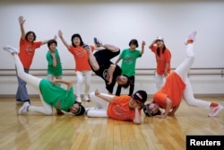 Members of Ara Style Senior, Japan's only breakdancing club made up of elderly citizens, and their teacher Yusuke Arai, 38, pose for a picture after their final rehearsal ahead of their performance at a festival in Tokyo, Japan, May 24, 2024. (REUTERS/Kim Kyung-Hoon)