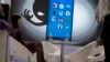 FILE - A woman sits near a display showing the dangers of hackers breaking into mobile devices during the Global Mobile Internet Conference in Beijing, China, April 29, 2016.