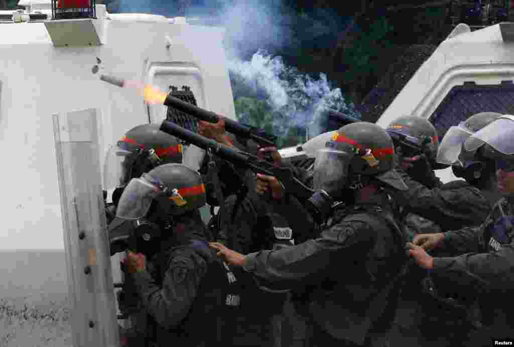 Polisi anti huru-hara menembakkan gas air mata saat bentrok dengan para pendukung kelompok oposisi yang melakukan rapat akbar menentang Presiden Nicolas Maduro di Caracas, Venezuela.