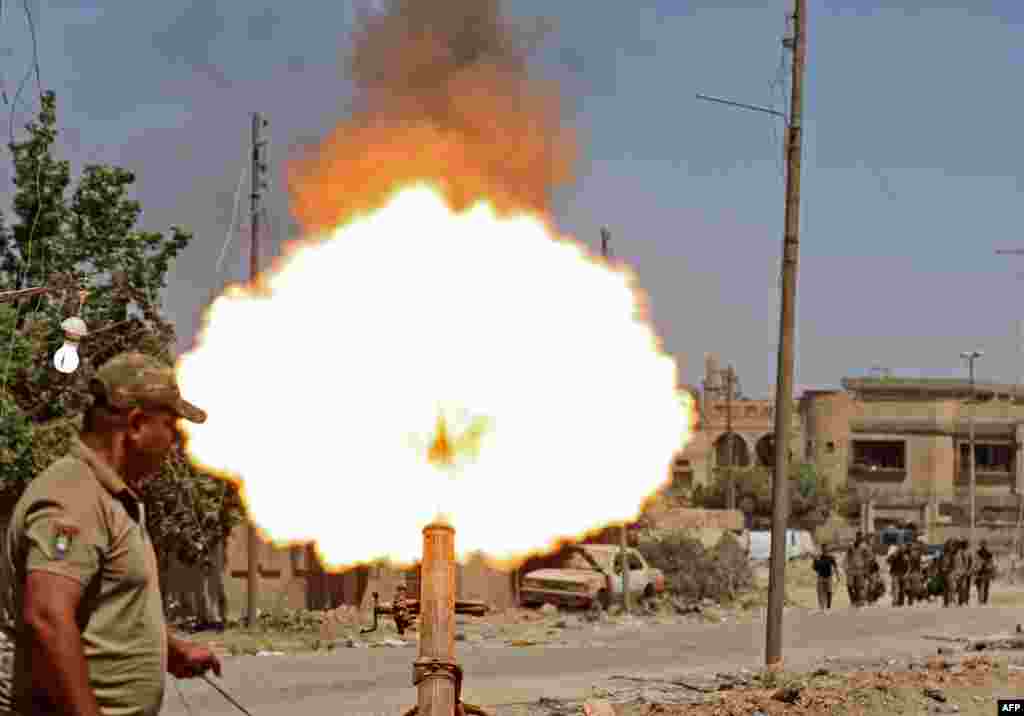 Seorang tentara Irak menembakkan mortir ke arah sasaran militan ISIS dari distrik Zanjili, Mosul barat.