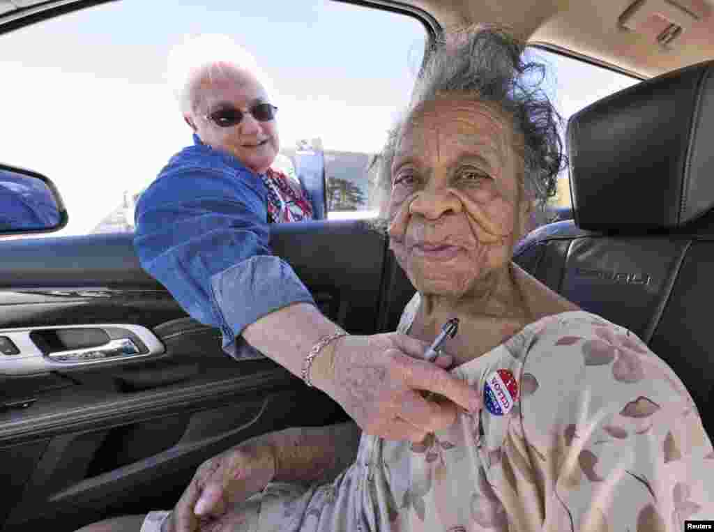 Grace Bell Hardison, perempuan AS berusia 100 tahun menerima tanda "I Voted Today" dari petugas, setelah ia memberikan suara dalam pemilu AS di TPS Belhaven, North Carolina.