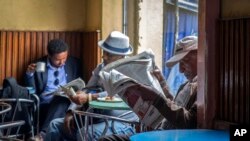 ኢትዮጵያውያን ጋዜጣ እያነበቡ። (ፎቶ ሙሉጌታ አየነ)