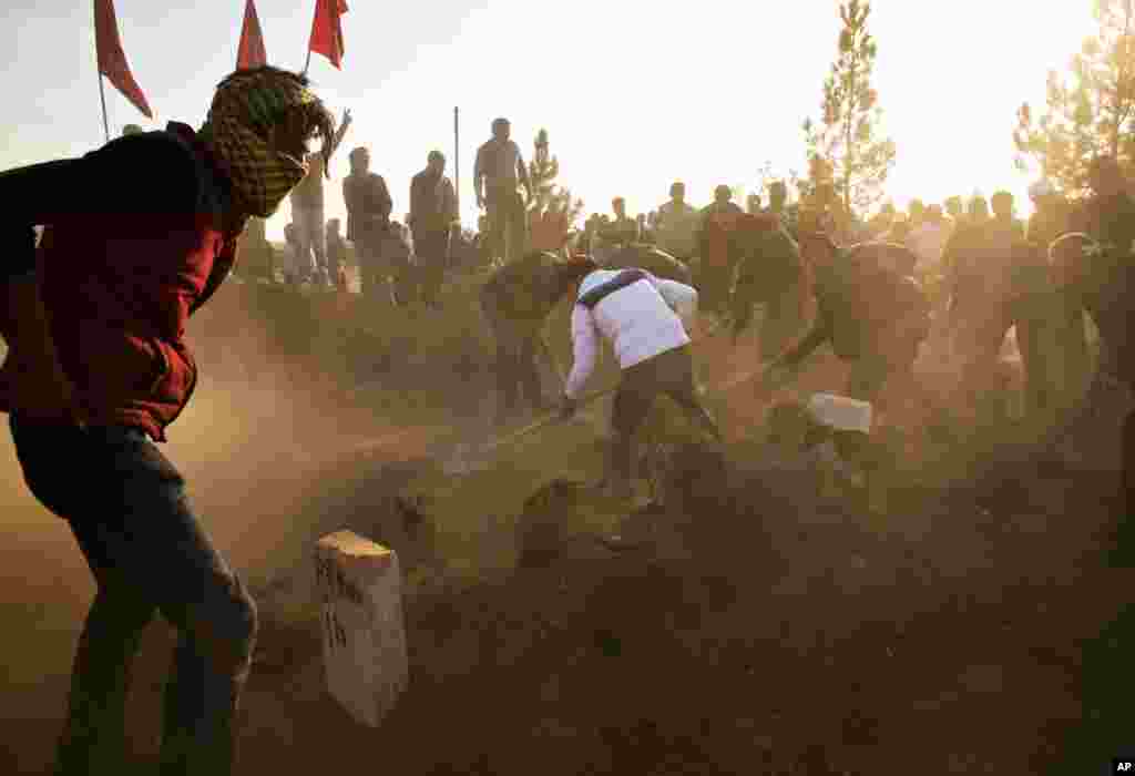 Des Kurdes recouvrent de la terre la tombe d'Ahmed Mustafa, combattant dqui est mort après avoir été blessé en combattant les forces Etat islamique dans la ville syrienne de Kobani, au cours de ses funérailles à Suruc, à la frontière entre la Turquie et la Syrie, novembre 12, 2014.