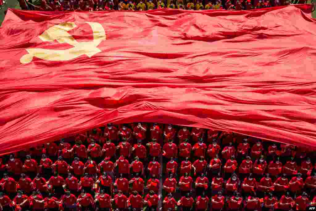 University students display a flag of the Communist Party of China to mark the party's 100th anniversary during an opening ceremony of the new semester in Wuhan in China's central Hubei province.