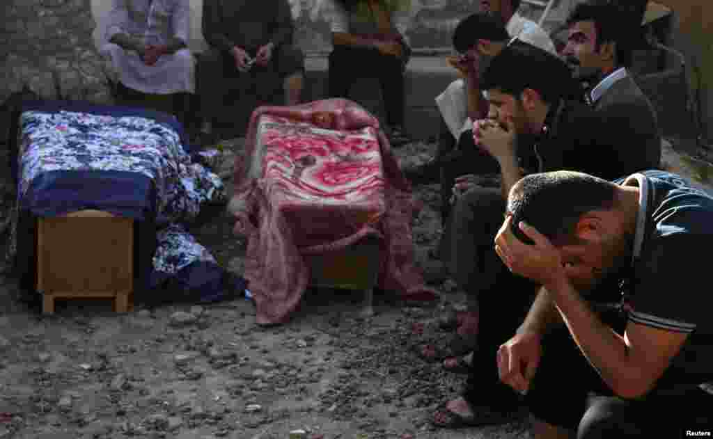 Mourners grieve during the funeral of victims who were killed in a Sunni mosque after two roadside bombs in Baquba, Sept. 13, 2013.