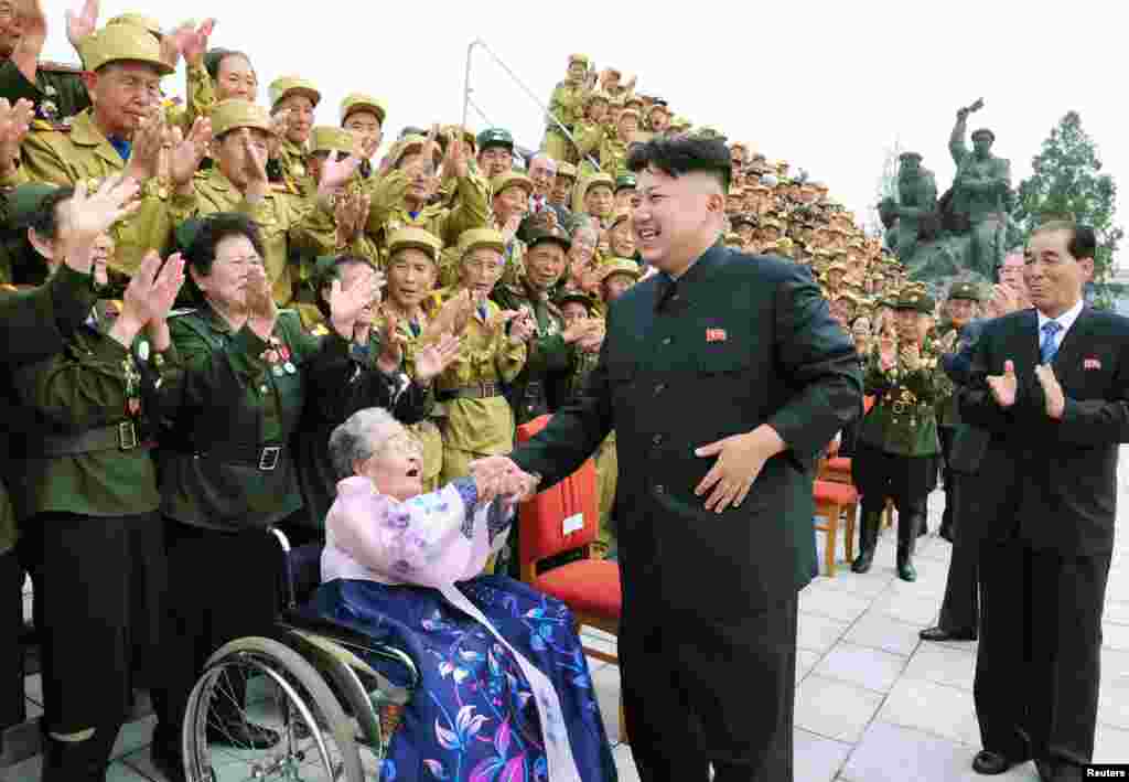 North Korean leader Kim Jong-Un laughs during a photo session in Pyongyang with war veteran delegates who took part in the celebrations of the 60th anniversary of the signing of the truce of the Korean War. (Photo released by North Korea's Korean Central News Agency)