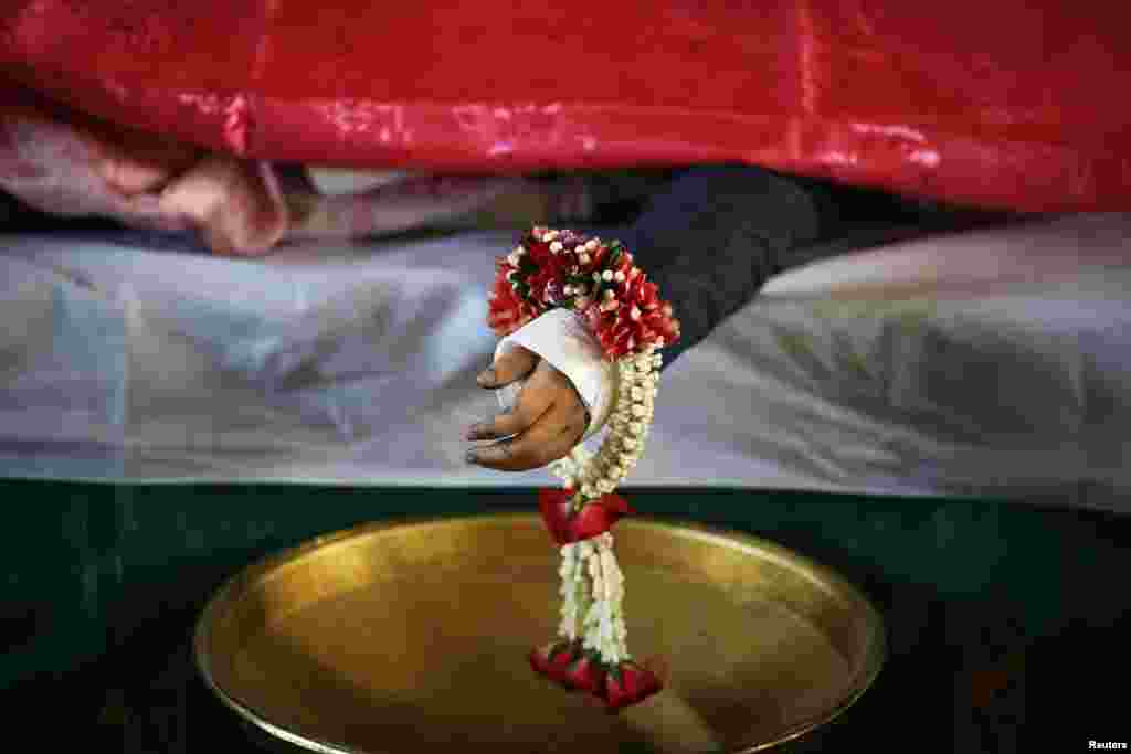 The body of one of the siblings killed in a bomb blast near an anti-government protest site on Feb. 23 is prepared for a funeral at a Buddhist temple, Bangkok, Feb. 24, 2014. 