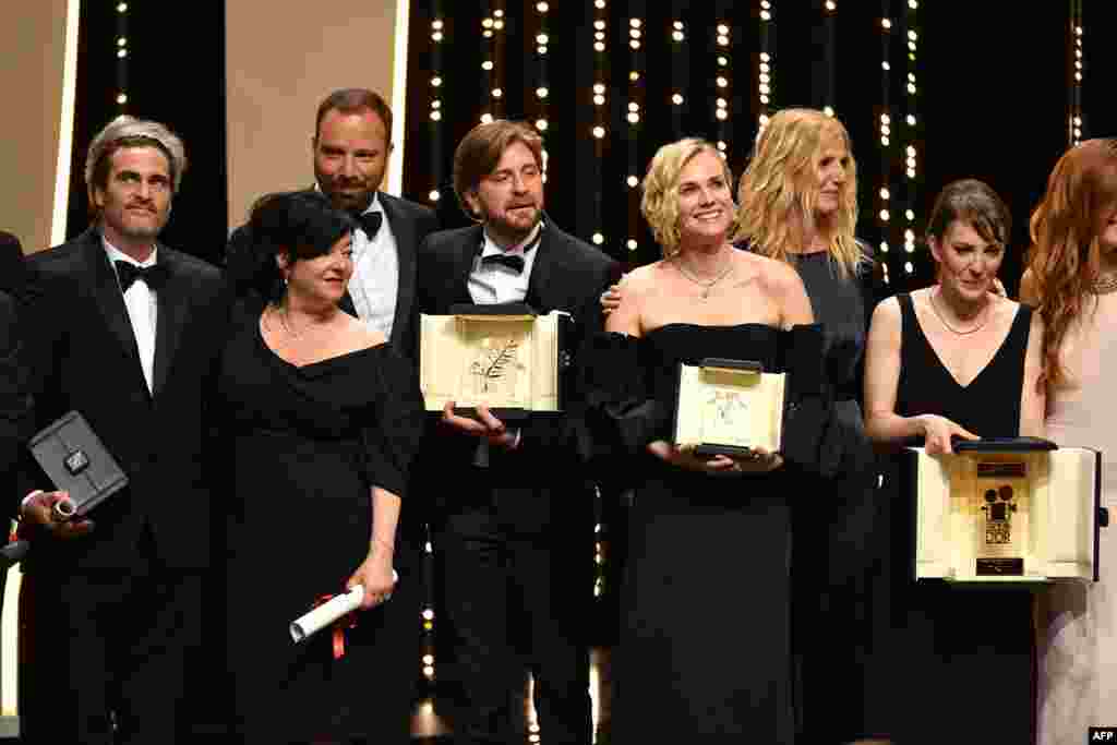 (From L) Best Actor prize laureate US actor Joaquin Phoenix, Best Screenplay co-laureates British director Lynne Ramsay and Greek director Yorgos Lanthimos, Palme d'Or laureate Swedish director Ruben Ostlund, Best Actress Prize laureate German actress Diane Kruger, French actress and President of the Camera d'Or jury Sandrine Kiberlain, Camera d'Or laureate French director Leonor Serraille and French actress Laetiti Dosch pose on stage on May 28, 2017 at the end of the closing ceremony of the 70th edition of the Cannes Film Festival in Cannes, southern France.