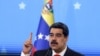Acompañado de sus nietas, el presidente de Venezuela, Nicolás Maduro, emite su voto durante las elecciones primarias del partido gobernante, el Partido Socialista Unido de Venezuela, en Caracas, el 8 de agosto de 2021.
