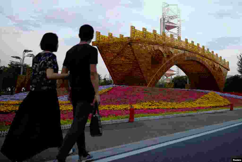 行人走过北京的大型雕塑《丝路金桥》(2017年5月10日)。有29 个国家的元首和政府首脑将出席5月14日至15日在北京的 “一带一路”国际合作高峰论坛。“一带一路”被中国称为是将改变世界大格局的顶级战略。美国派出由川普行政当局的高级顾问兼国家安全委员会负责东亚事务的马修·波廷格率领的代表团参加。