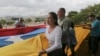 ARCHIVO - La líder opositora María Corina Machado, exdiputada a la Asamblea Nacional, ayuda a llevar su bandera nacional durante una protesta contra las elecciones presidenciales, en Caracas, Venezuela, el 21 de mayo de 2018.