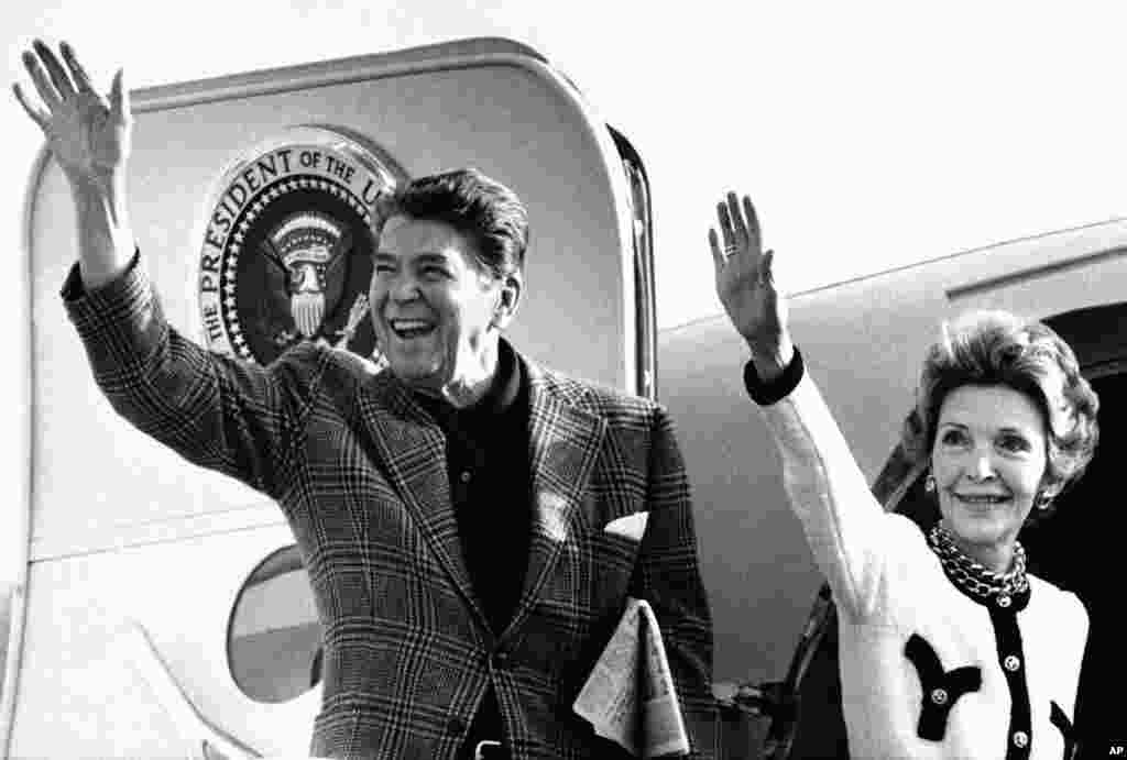 Presiden AS Ronald Reagan dan istrinya Nancy melambaikan tangan dari pintu pesawat Air Force One di Bandar Udara Internasional Los Angeles, California, 29 Desember 1984. Mereka akan menuju Palm Springs, California, untuk liburan Tahun Baru. (AP/Ira Schwarz)