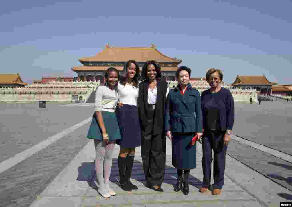 美国第一夫人米歇尔.奥巴马、她的女儿玛丽雅和萨莎，以及她的母亲罗宾逊女士3月21日在参观北京的故宫时与中国国家主席习近平的夫人彭丽媛合影。