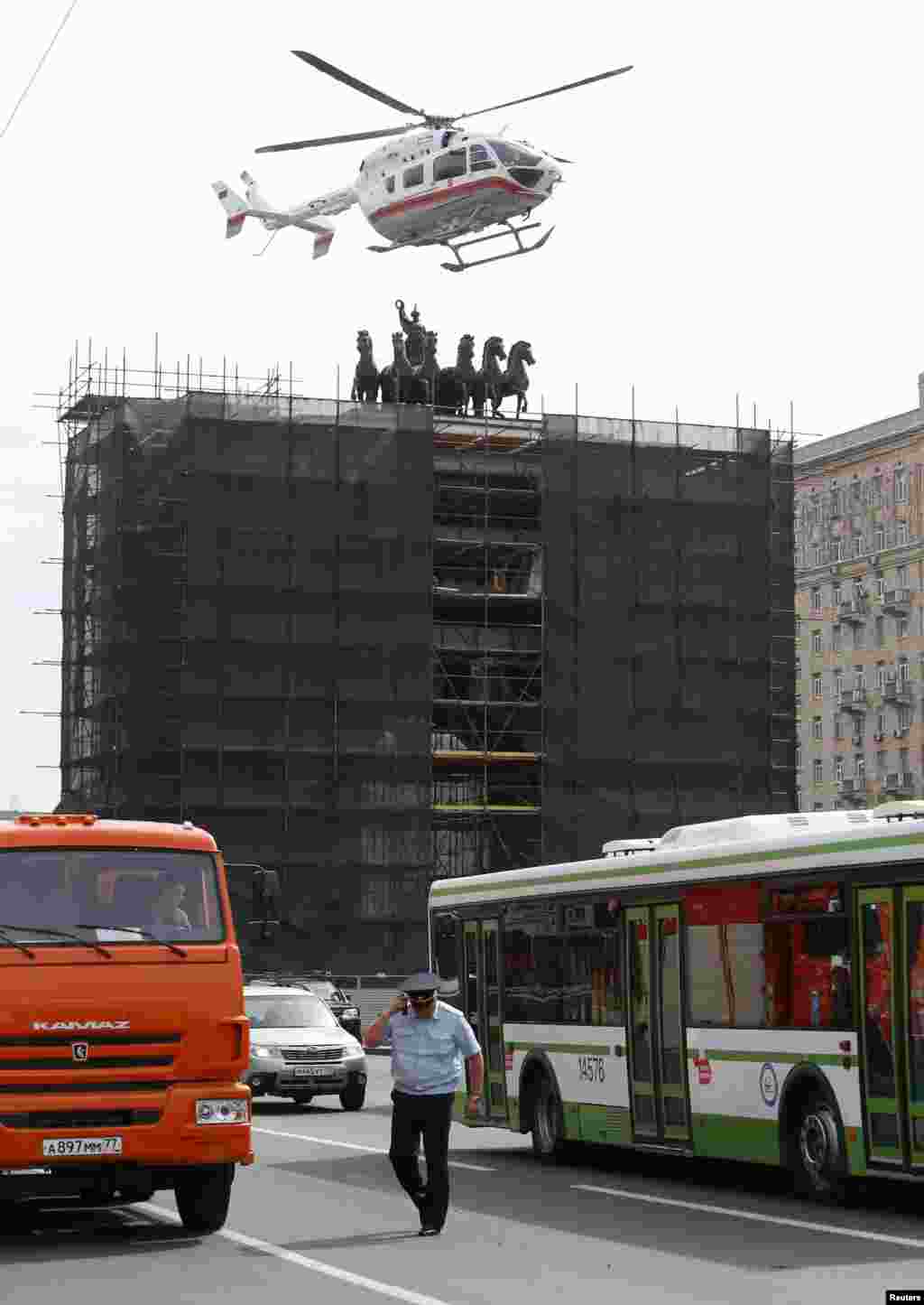 Sebuah helikopter layanan darurat mendekati pintu masuk stasiun kereta menyusul kecelakaan di kereta bawah tanah di Moskow (15/7). (Reuters/Sergei Karpukhin)